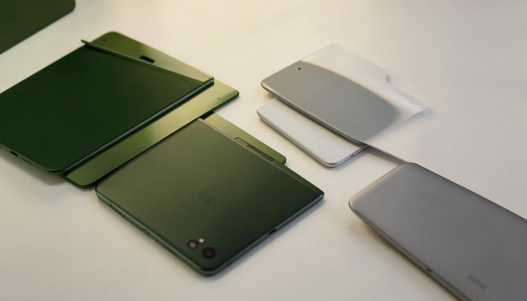 Un éclairage doux et chaleureux sur une surface claire mettant en valeur des silhouettes épurées de smartphones et gadgets